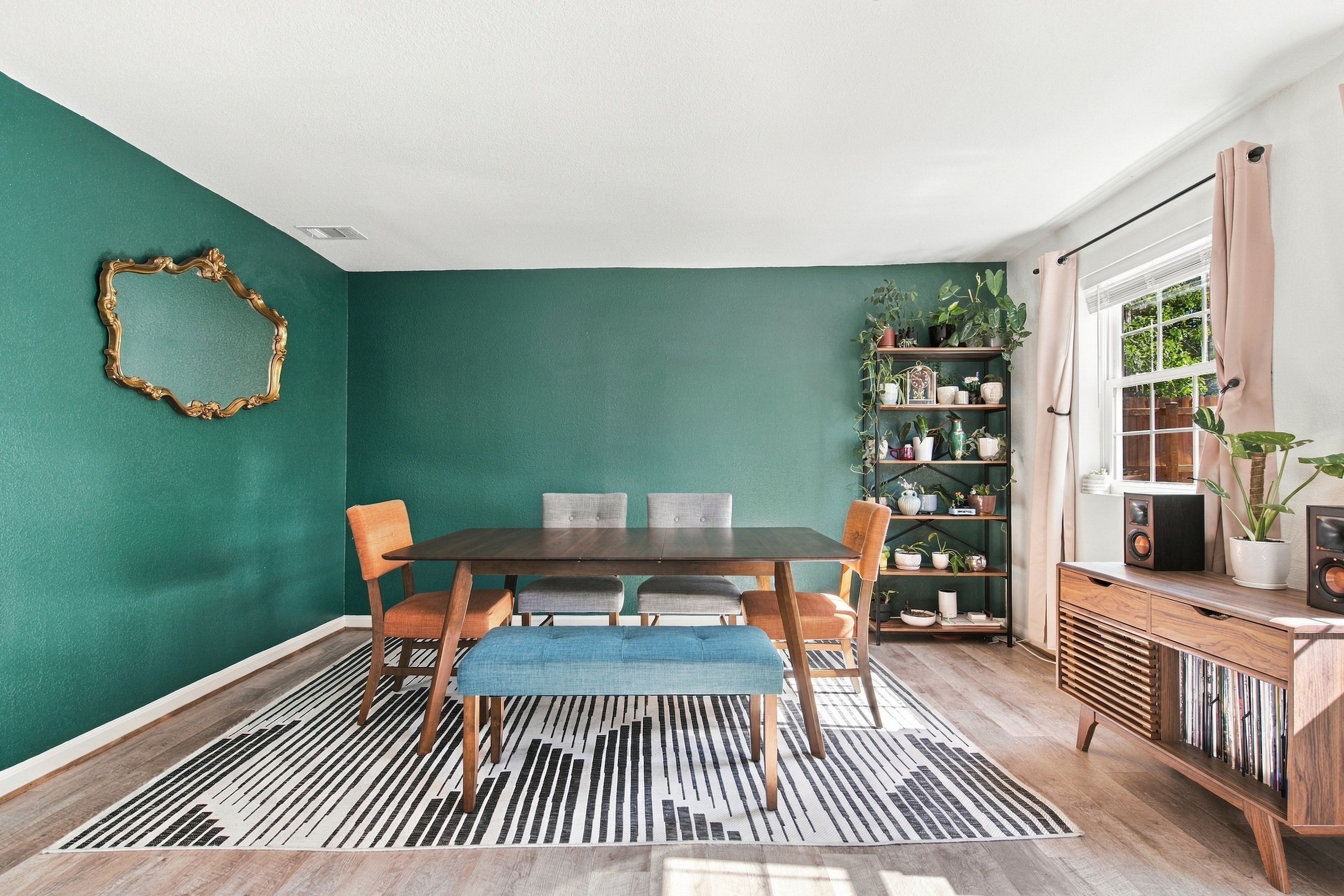 Modern dining room with teal walls and mid-century furniture